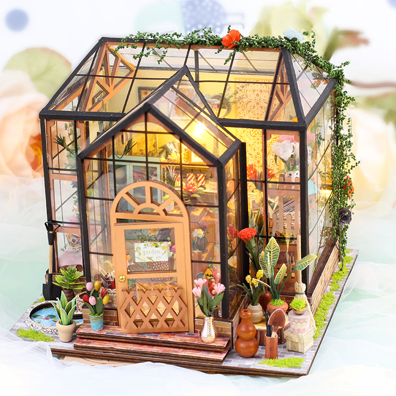 DIY dollhouse kit featuring a detailed miniature greenhouse with plants and vibrant interiors, perfect for crafting enthusiasts.