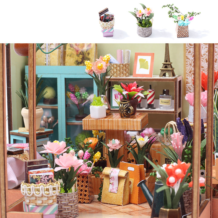 Colorful miniature flower arrangements in a DIY dollhouse scene with various plants and decorative items.