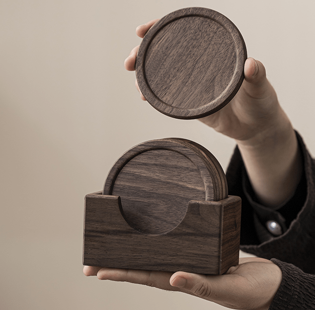 Minimalist walnut wooden coasters being held, showcasing natural texture and elegant design for home decor.