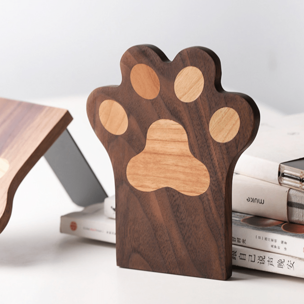 Cute cat paw bookend in walnut wood, adding charm and stability to books on a shelf.