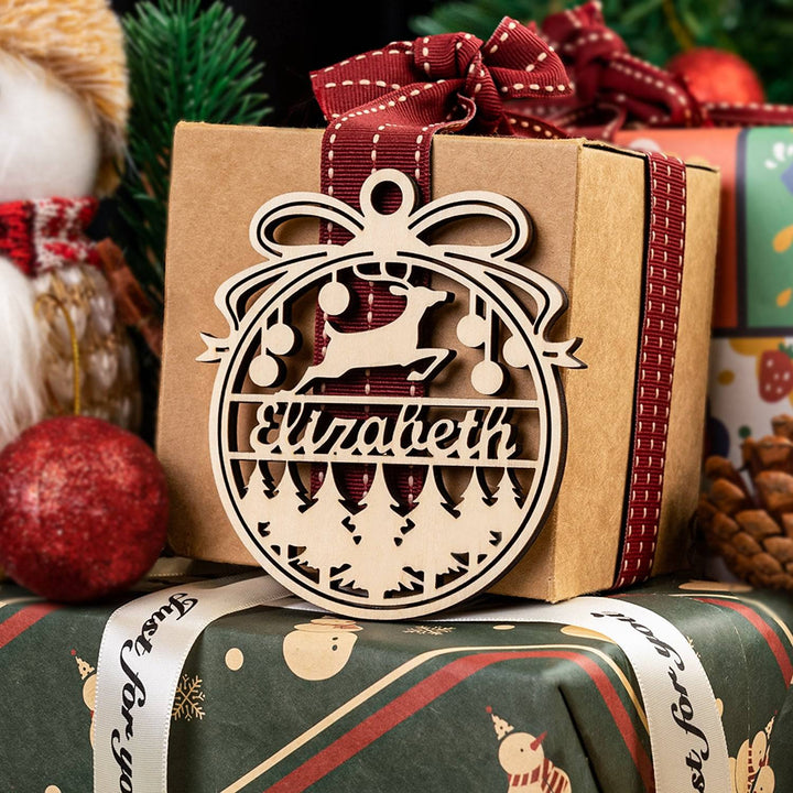 Personalized wooden ornament with the name Elizabeth, decorated with a bow, hanging on a gift box for Christmas.
