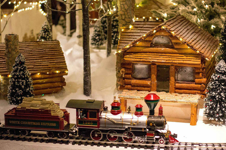 Christmas Train Paradise puzzle scene with a decorated model train, log cabin, and snowy trees for a festive atmosphere.