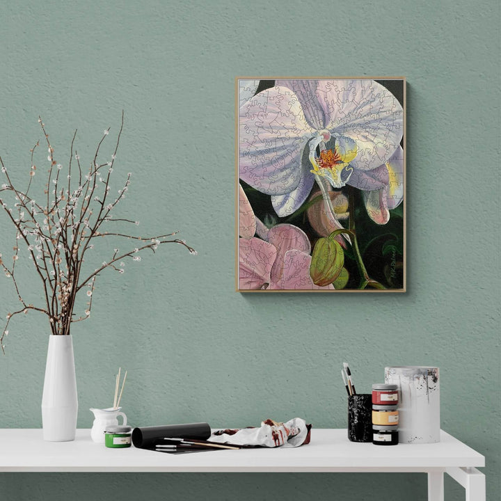 Orchid artwork by Marianne K Palmer displayed on a stylish green wall, featuring vibrant colors and intricate details.