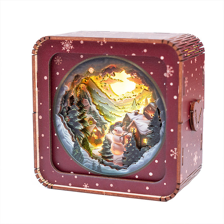 3D wooden puzzle night light featuring a snowman in a snowy mountain scene with a warm glow.