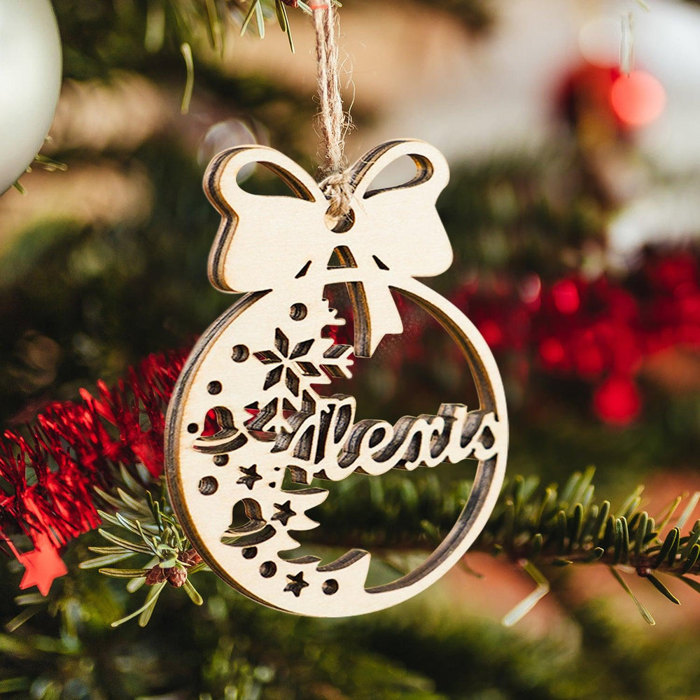 Personalized wooden Christmas ornament with name 'Alexis', adorned with a bow and festive design, hanging on a tree.