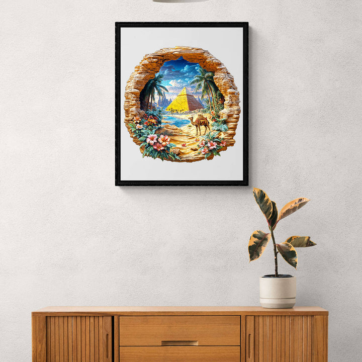 Art print of an oasis landscape with a pyramid, displayed in a modern wooden frame and natural decorations.