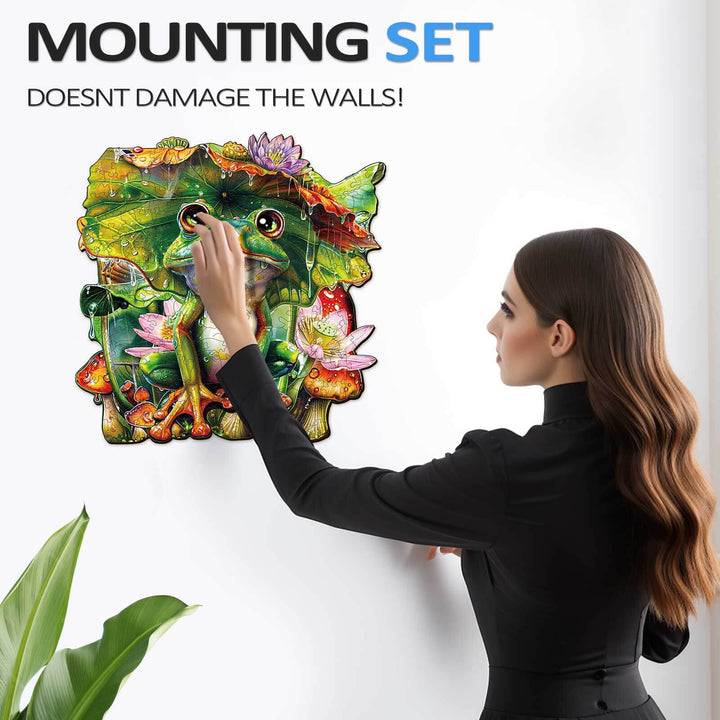 A woman applying a frog wooden jigsaw puzzle to the wall using a mounting set that protects the surface.
