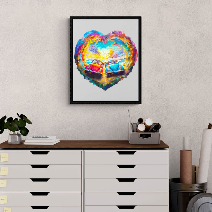 Colorful heart-shaped artwork featuring two vintage cars, displayed on a modern desk with stationery.