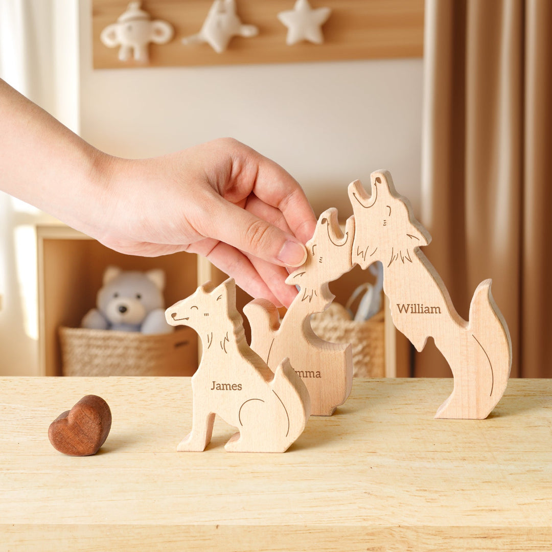 Hand placing wooden wolf family puzzle pieces named James, Emma, and William on a table, showcasing family love.