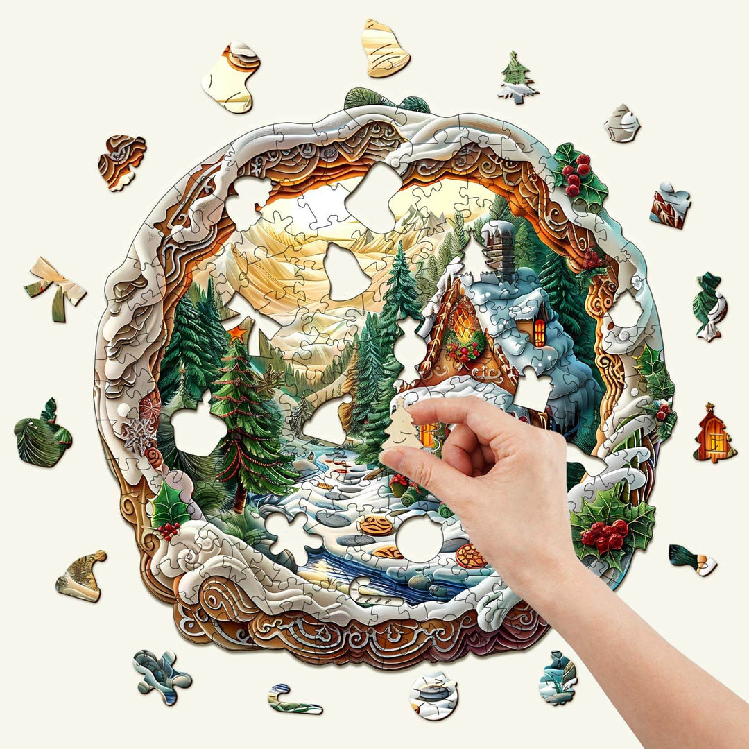 3D Christmas House-1 wooden jigsaw puzzle, hand placing a piece in a scenic winter landscape.