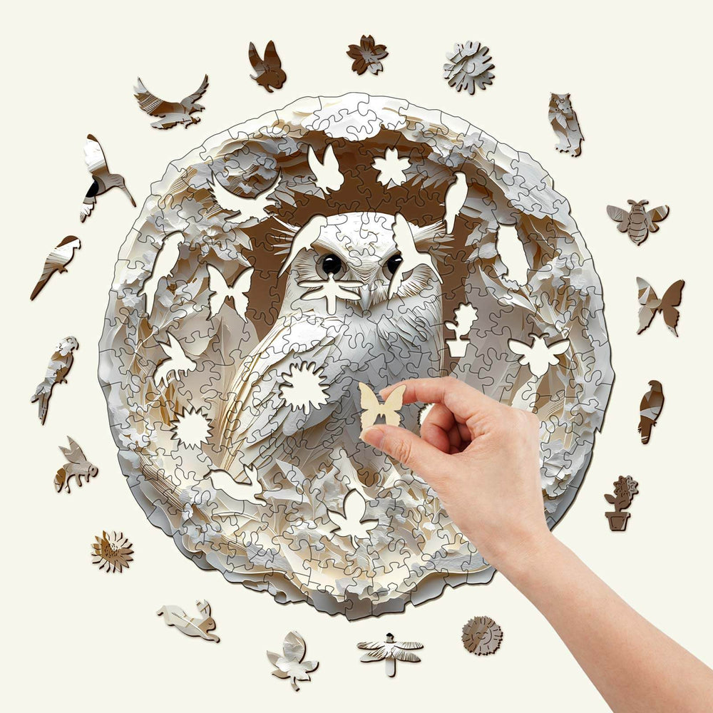 3D Paper Carved Owl Wooden Jigsaw Puzzle with hand placing a piece, showcasing intricate design and nature motifs.
