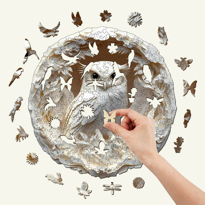 3D Paper Carved Owl Wooden Jigsaw Puzzle with hand placing a piece, showcasing intricate design and nature motifs.