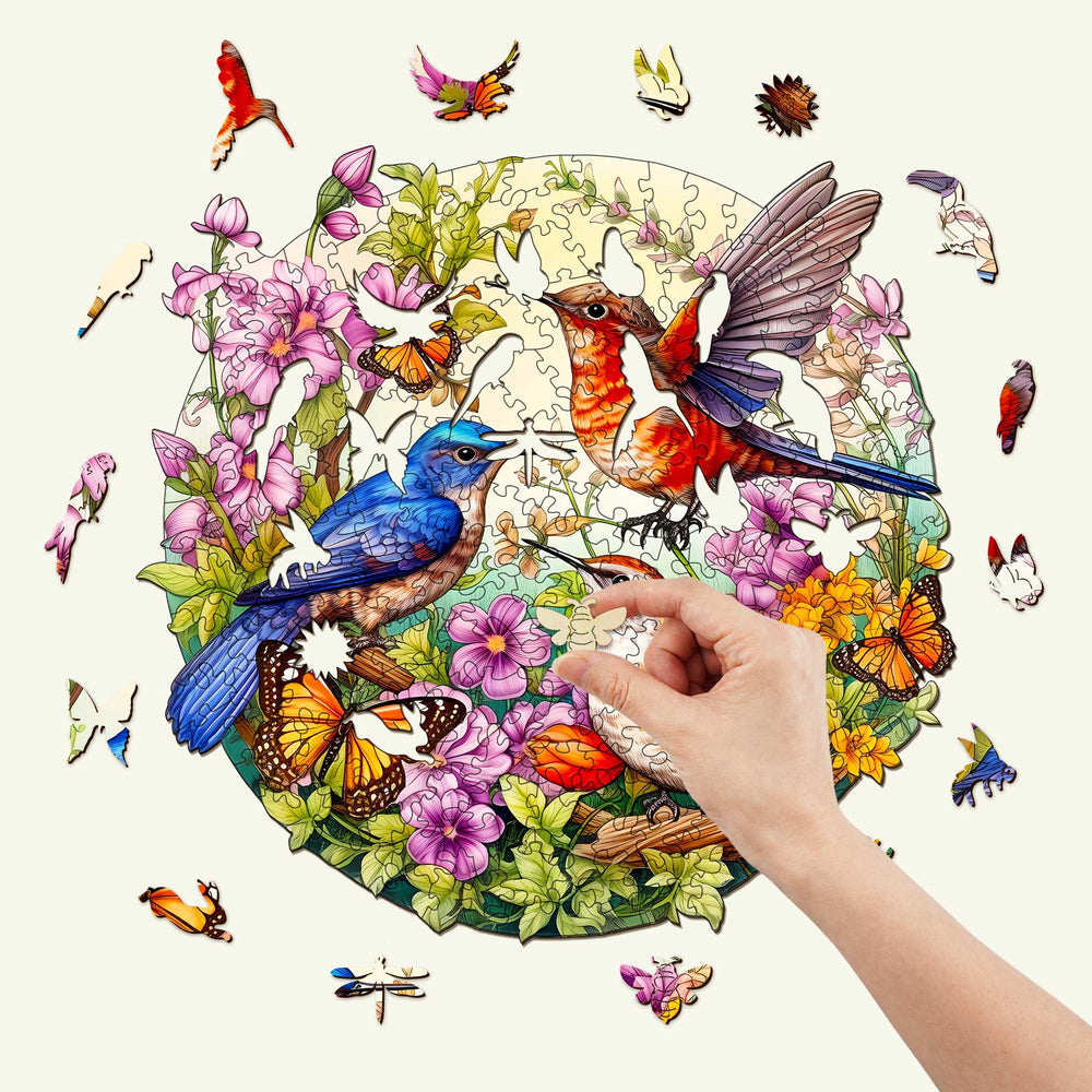 Colorful birds and butterflies wooden jigsaw puzzle with hand placing a piece amidst floral design.