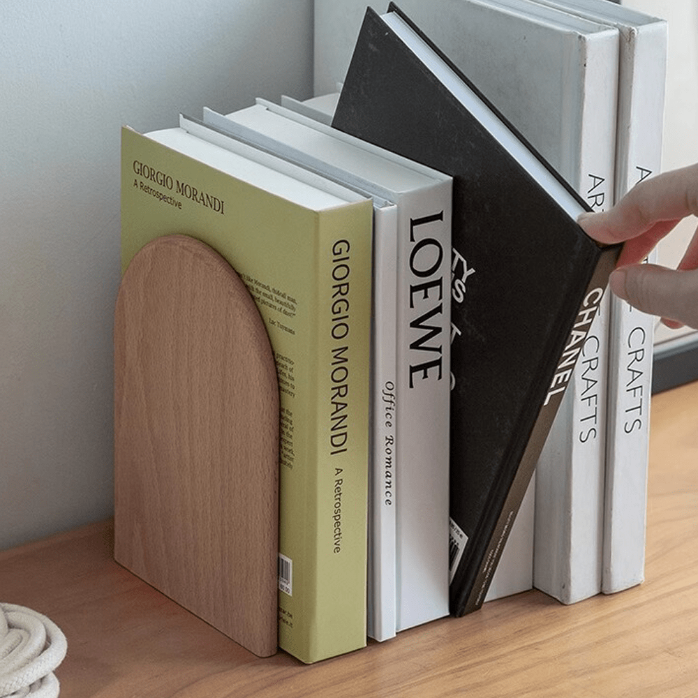 Wooden bookends elegantly supporting books with a modern design on a wooden surface.