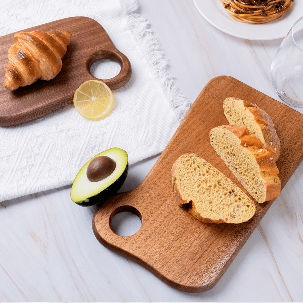 Ring-shaped mini cutting board with croissant and sliced bread, showcasing walnut wood texture and design.