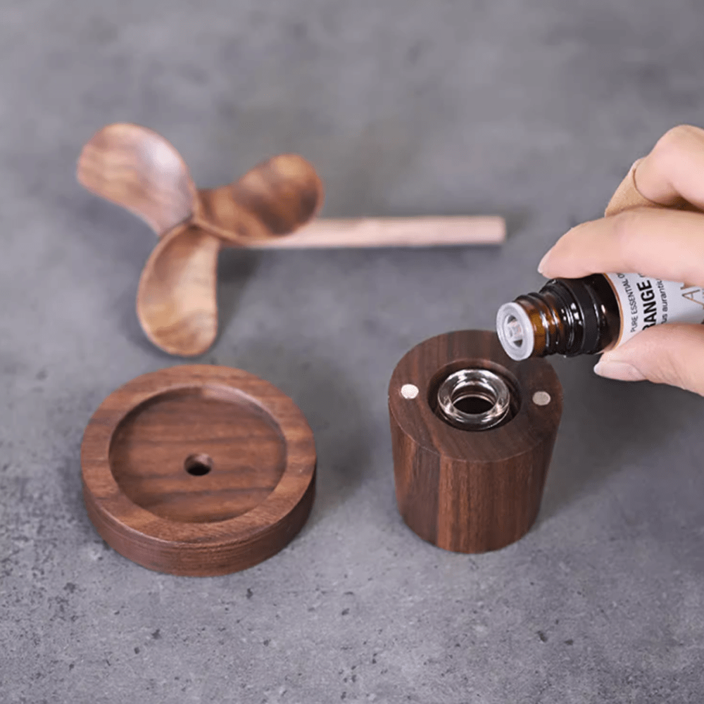 Wooden aromatherapy diffuser made of walnut wood with essential oil bottle and wooden spoon, showcasing natural elegance.