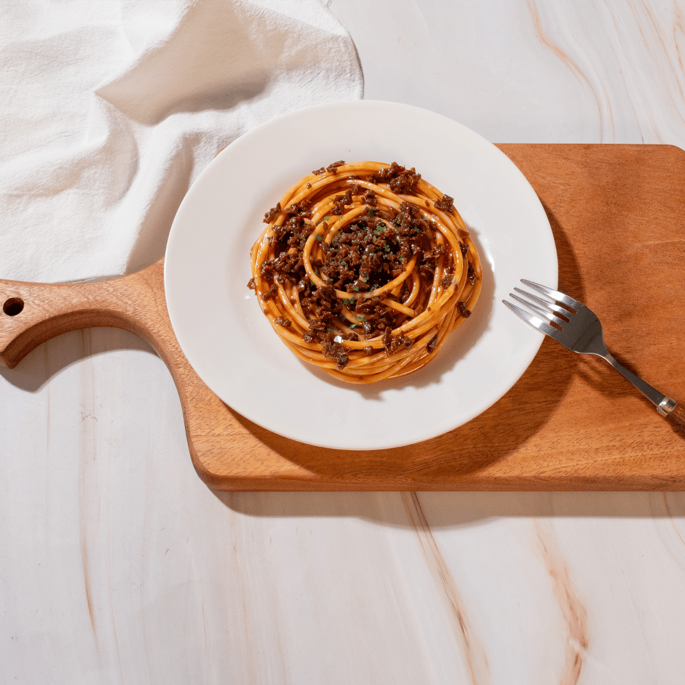 Plate of spaghetti served on a multi-functional branch design cutting board, highlighting its artistic kitchen appeal.