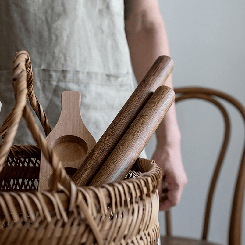 Basket with wooden rolling pins and utensils, ideal for baking pastries and cooking.