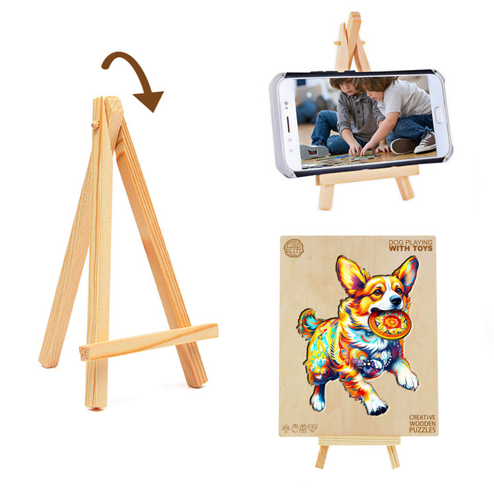 Wooden jigsaw puzzle of a dog playing with toys displayed on an easel next to a phone showing puzzle-solving images.