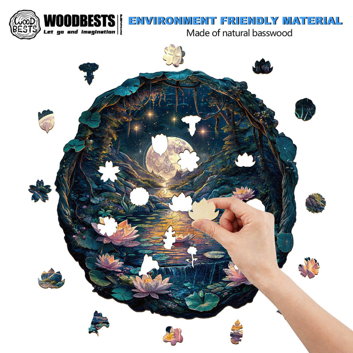 Person assembling a 3D wooden jigsaw puzzle featuring a moonlit cave and lotus flowers.