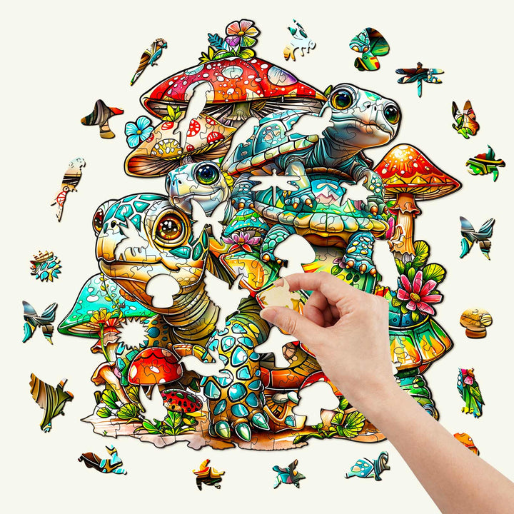 Hand placing a piece in the Turtle Family Wooden Jigsaw Puzzle featuring colorful turtles and mushrooms.