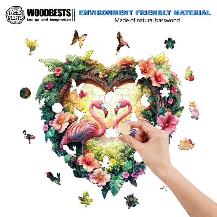 Hand placing a piece in the Love Flamingos wooden jigsaw puzzle featuring vibrant flora and two flamingos.