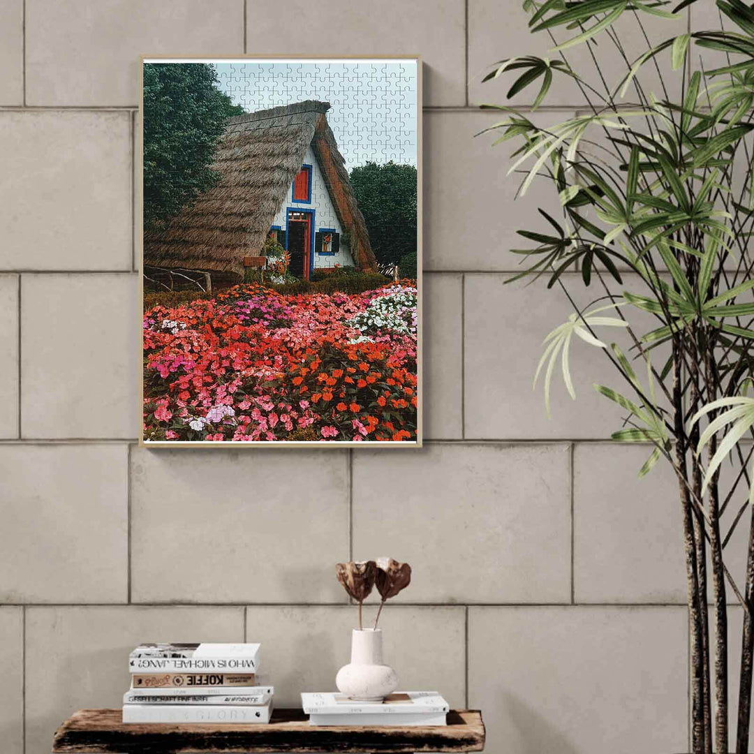 Flower House 500/1000 piece puzzle showcasing a thatched cottage surrounded by vibrant flowers, perfect for puzzle enthusiasts.