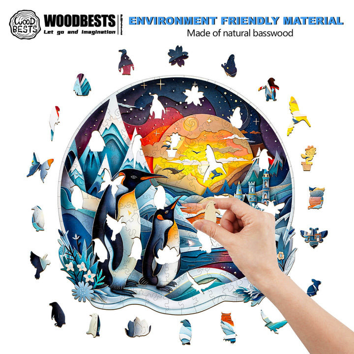 A hand assembling a 3D penguin family wooden jigsaw puzzle made from natural basswood, showcasing an ocean and mountain scene.