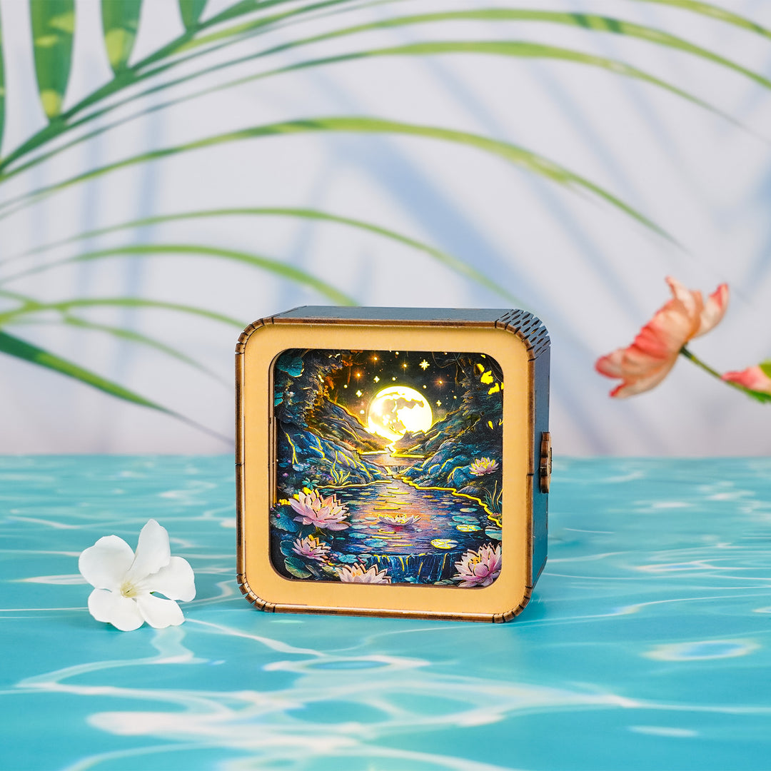 3D wooden puzzle night light featuring a moonlit lotus pond scene with glowing stars and water lilies.