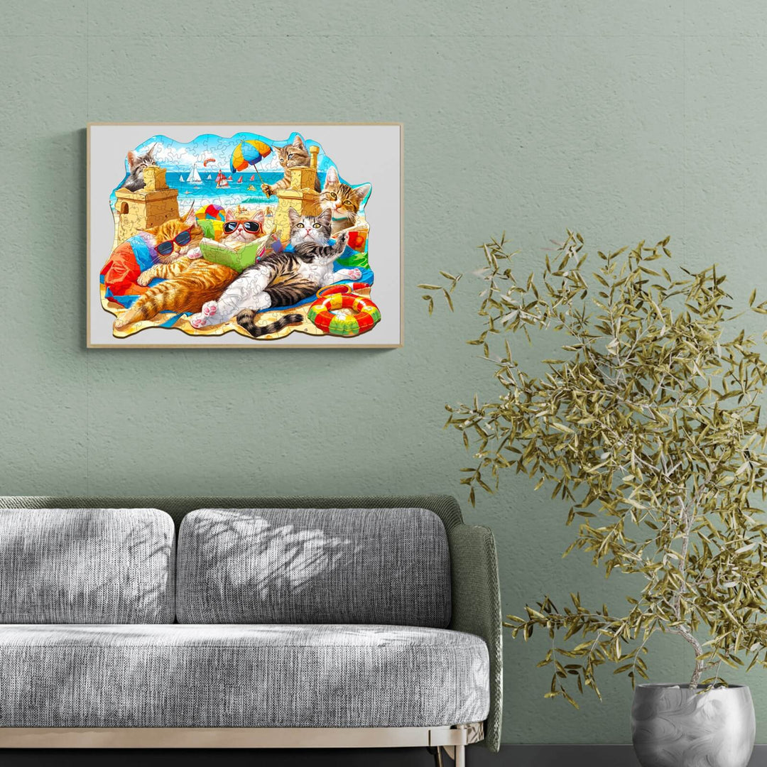 Colorful Beach Cat wooden jigsaw puzzle displayed on a wall above a gray sofa, enhancing living room decor.