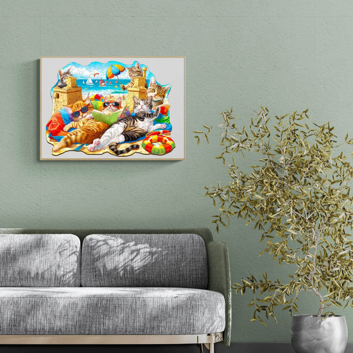 Colorful Beach Cat wooden jigsaw puzzle displayed on a wall above a gray sofa, enhancing living room decor.
