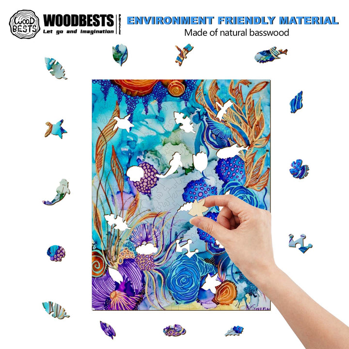 A hand assembling a colorful natural basswood puzzle with aquatic-themed pieces, showcasing artistic design.