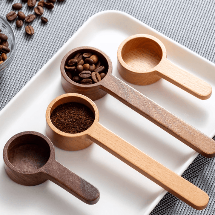 Set of four wooden measuring spoons on a plate, suitable for precise cooking and baking, showcasing natural wood grain.