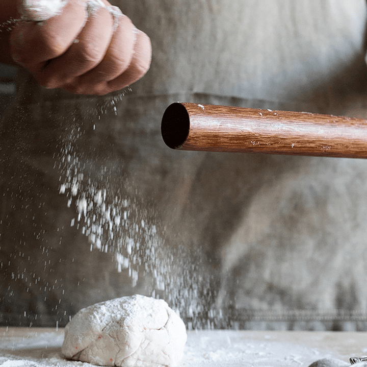 Person using a no paint, no wax rolling pin to roll dough for pastries and dumplings.