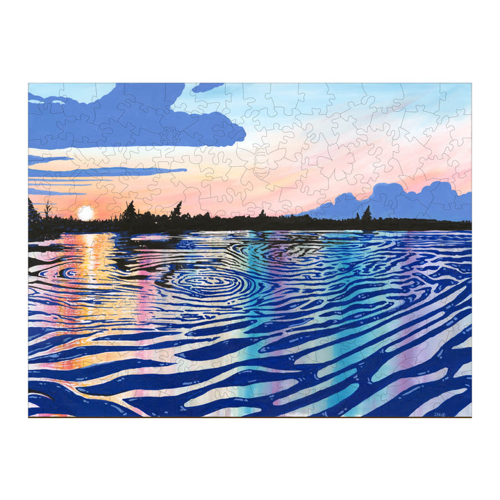 Black Rapids View puzzle by Sarah Bradfield featuring sunset reflections on water, vibrant colors, and artistic inspiration.