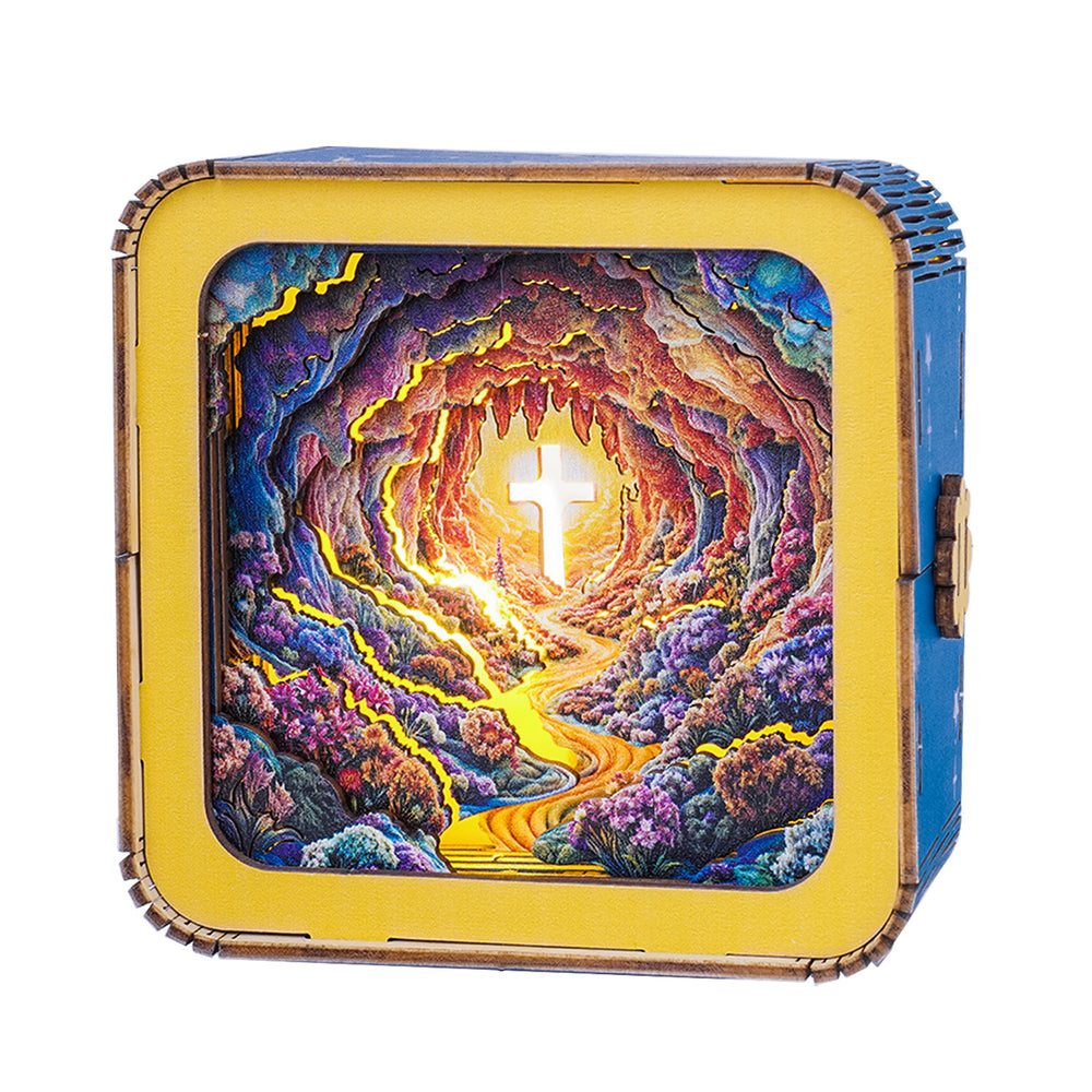 3D wooden puzzle night light featuring a scenic cave with a glowing cross at the end of a winding path.