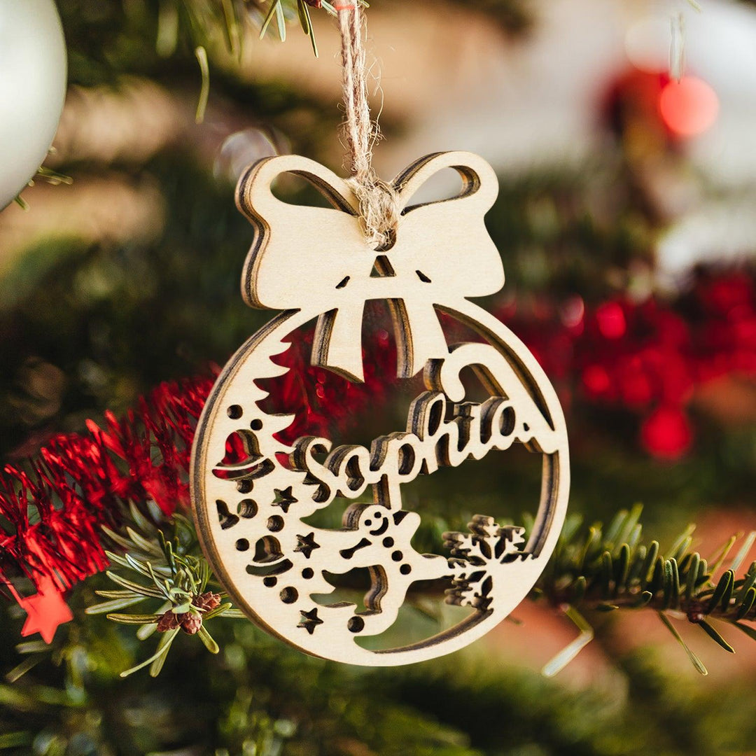 Personalized Christmas wooden ornament with bow and name "Sophia", hanging on a decorated tree.