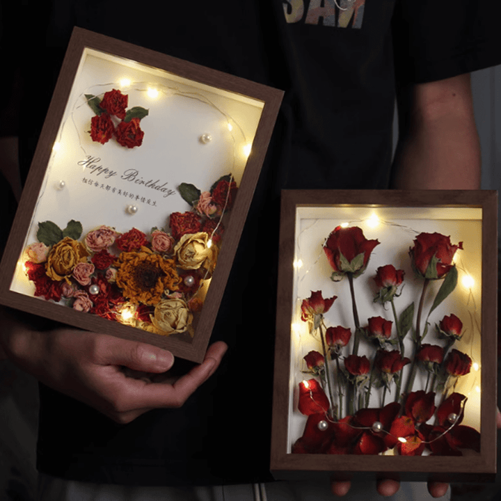 Two illuminated deep inner frame specimen photo frames with dried flowers and a birthday message.