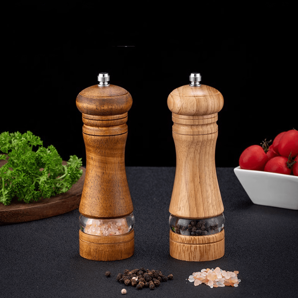 Two-tone rubberwood spice grinder set with transparent shaker, featuring salt and pepper, on a black background.