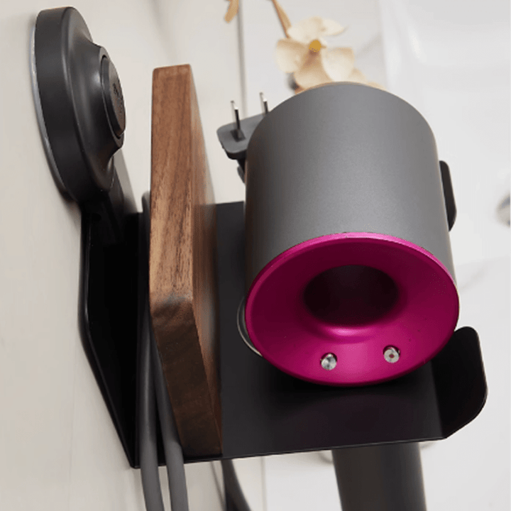 Suction cup hair dryer holder in natural walnut and aluminum, showcasing damage-free wall storage.