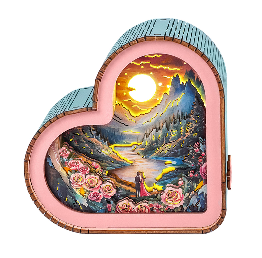 Heart-shaped 3D wooden puzzle night light featuring a romantic sunset scene with roses and lovers by a river.