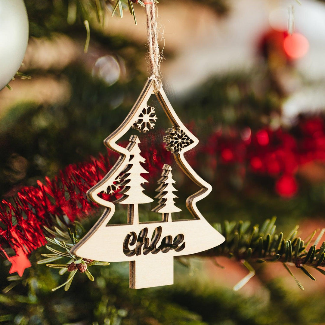 Personalized wooden Christmas tree ornament with name 'Chloe' hanging on a Christmas tree.