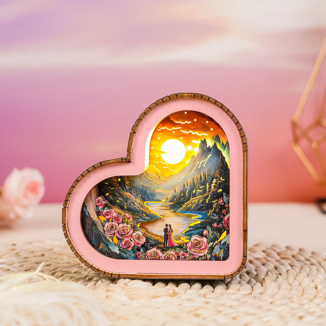Heart-shaped 3D wooden puzzle night light featuring a romantic sunset landscape with roses.