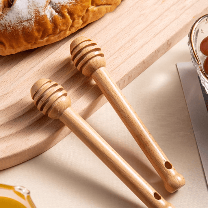 Beechwood stirring sticks on a wooden board, ideal for stirring honey, tea, and jams, showcasing natural texture and warm tones.