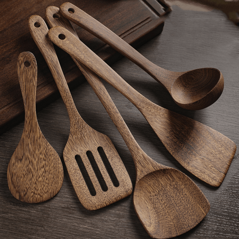Five-piece wooden kitchenware set featuring cooking, stirring, and serving utensils on a wooden surface.