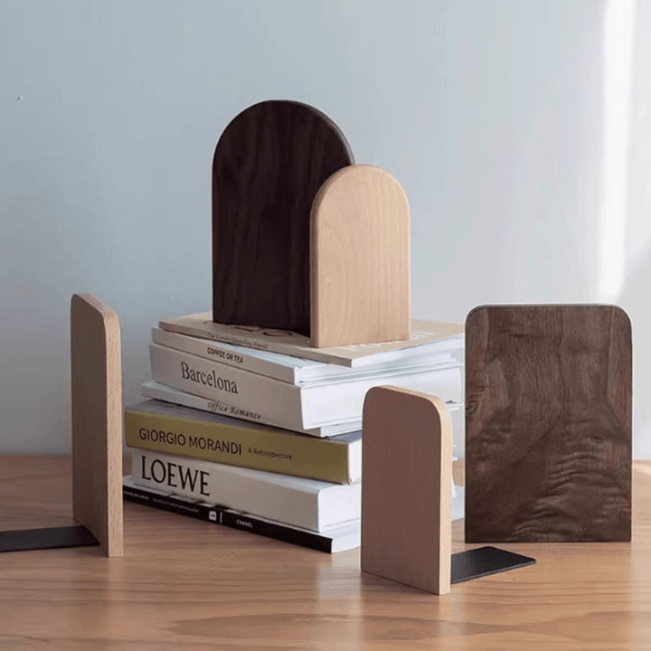 Wooden bookends in walnut and beech, stylishly supporting stacked books on a table.