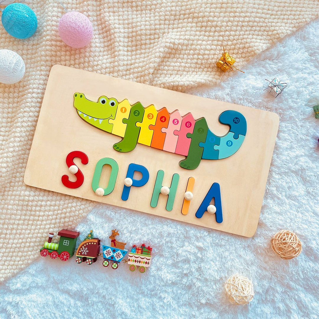 Personalized wooden animal puzzle featuring crocodile and colorful letters spelling 'SOPHIA' on a soft background.
