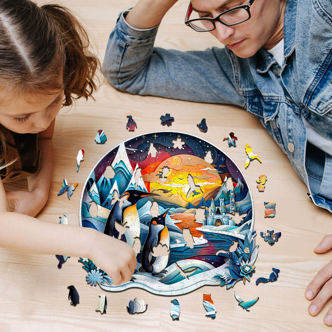 A child and adult assembling a colorful 3D penguin family wooden jigsaw puzzle on a wooden table.