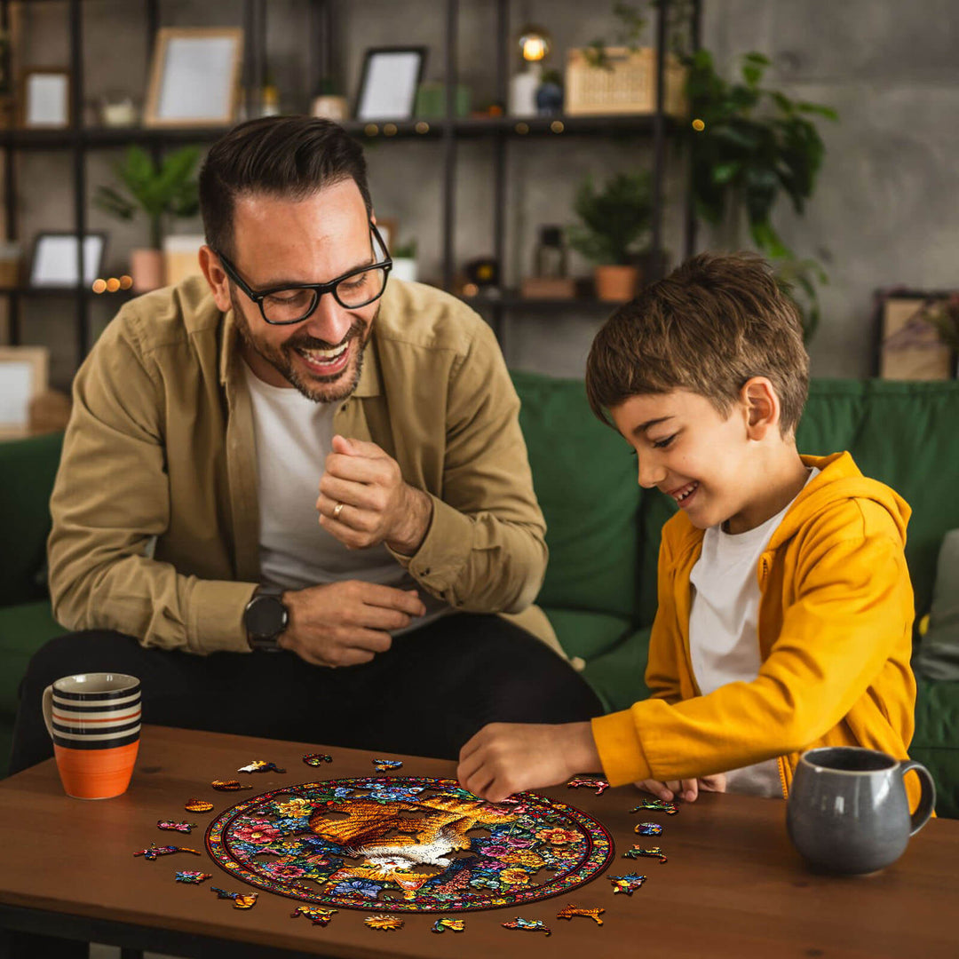 A father and son joyfully solving a Floral Feline wooden jigsaw puzzle together at home.