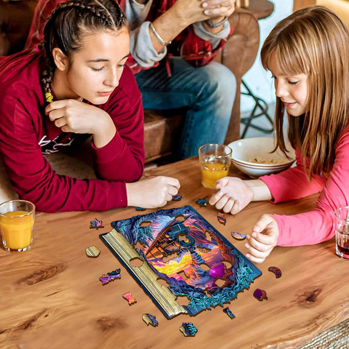 Two girls focused on assembling a 3D Aurora Train wooden jigsaw puzzle on a table with drinks around them.
